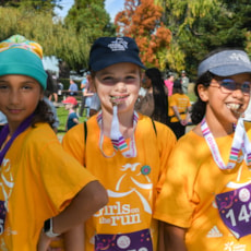 Three Girls on the Run participants smile while showing off 5K medals
